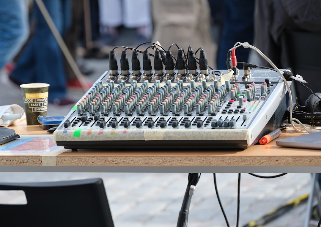 Professional audio mixing console with colorful faders and knobs in a broadcast studio